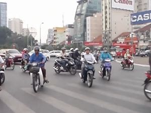 Walking across a busy roundabout in the centre of Ho Chi Minh City, Vietnam